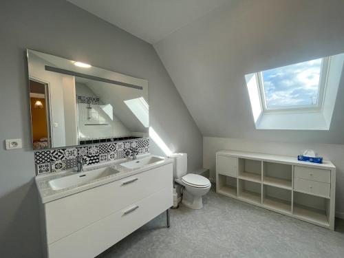 a bathroom with a sink and a toilet and a mirror at Maison Belle Étoile à 5 min de la plage in Les Moitiers-dʼAllonne