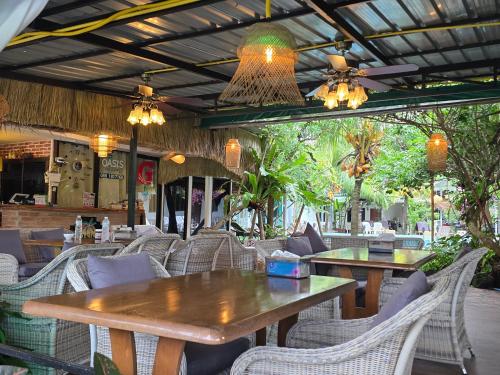 an empty restaurant with tables and chairs and lights at OASIS Phuket Airport in Nai Yang Beach