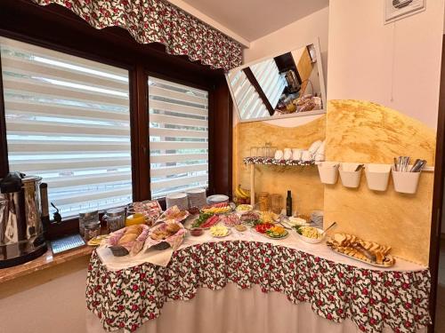 a table with food on it next to a window at Pensjonat Szach in Krynica Zdrój