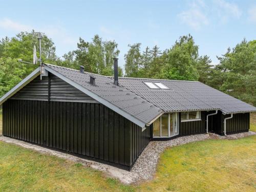 a black house with a black roof at Holiday Home Selver - 250m from the sea by Interhome in Hals