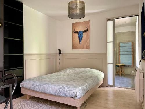 a bedroom with a bed and a picture of a cow on the wall at Besançon: charmant duplex au pied de la citadelle in Besançon