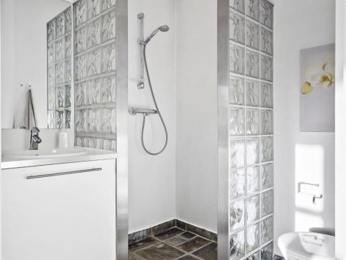a white bathroom with a shower and a sink at Holiday Home Nele - 400m from the sea by Interhome in Hals