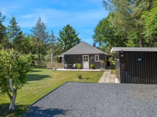 ein Haus mit einem schwarzen Zaun und einem Hof in der Unterkunft Holiday Home Marise - from the sea by Interhome in Hals