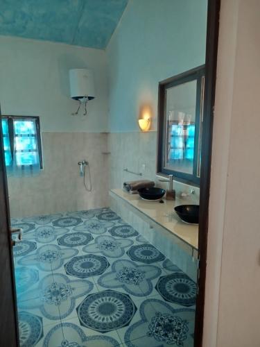 ein Bad mit 2 Waschbecken und Fliesenboden in der Unterkunft Villa meuble a louer Anakao in Anakao