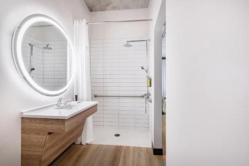 a white bathroom with a sink and a mirror at The LOOM Hotel, Tapestry Collection by Hilton in Warwick