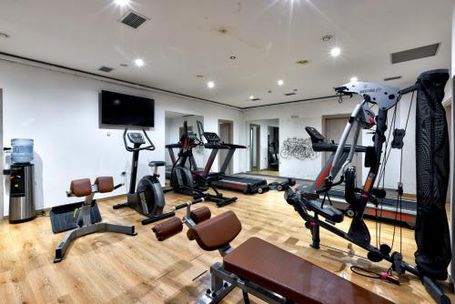 a gym with several exercise bikes and a flat screen tv at Cavo Orient Beach Hotel & Suites in Tragaki