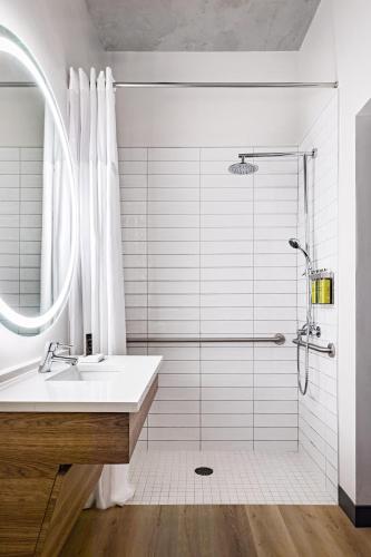 a bathroom with a sink and a shower at The LOOM Hotel, Tapestry Collection by Hilton in Warwick