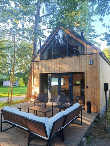 a small wooden house with a bench on a deck at Domek Pod Jemiołami - Mały Głęboczek in Mały Głęboczek