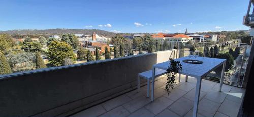 a blue table on a balcony with a view of a city at Luxury Barton Apartment with Views in Prime Location in Barton