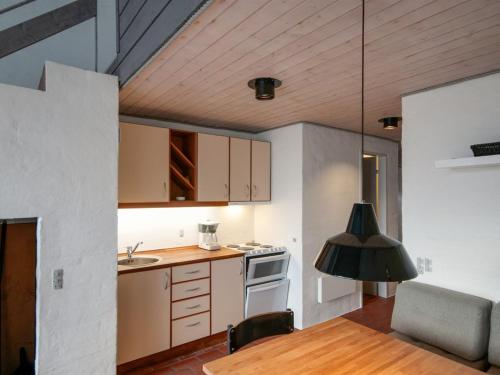 a kitchen with a table and a stove top oven at Apartment Edisa - 50m from the sea by Interhome in Brovst
