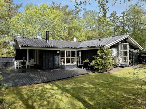 a house with a wooden deck in the yard at Holiday Home Amabel - 200m from the sea by Interhome in Hals