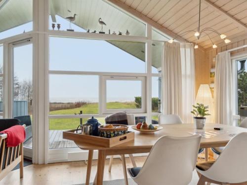 a dining room with a table and chairs and a large window at Holiday Home Hane - 150m from the sea by Interhome in Hadsund