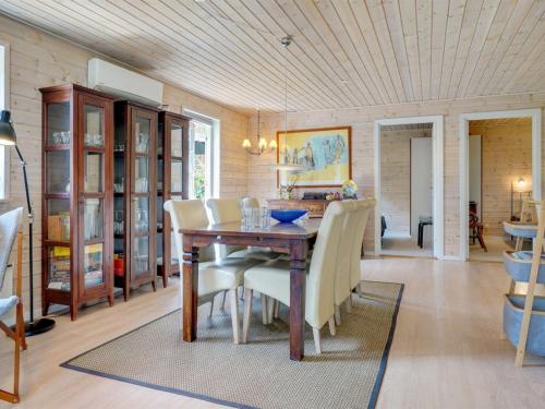 a dining room with a wooden table and chairs at Holiday Home Tian - from the sea by Interhome in Hadsund