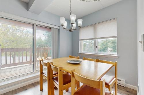 a dining room with a wooden table and chairs and a large window at 5A Mountain Village - Unit A in Dover