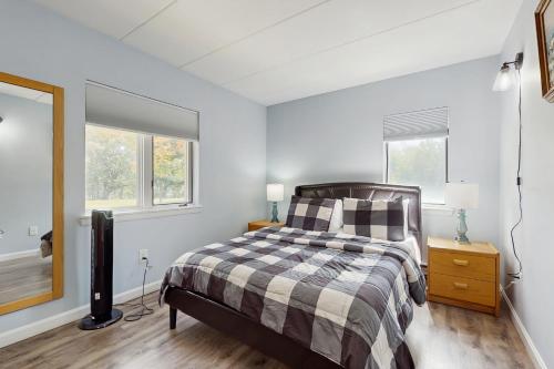 a bedroom with a bed and two windows at 5A Mountain Village - Unit A in Dover