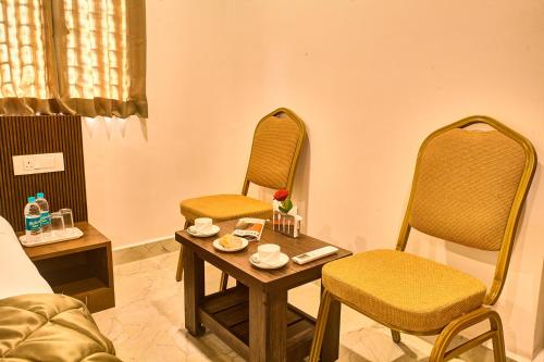een kamer met 2 stoelen en een tafel en stoelen bij Arrival Inn Transit Hotel Bangalore Airport in Bangalore