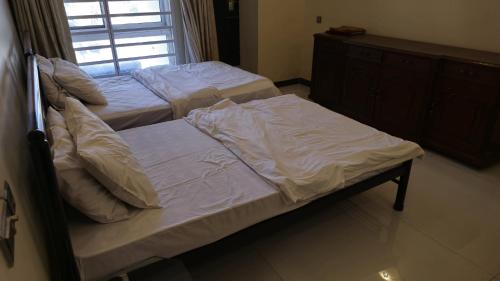 two twin beds in a bedroom with a window at Home Sweet Home in Karachi