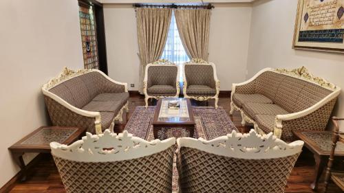 a living room with wicker chairs and a table at Home Sweet Home in Karachi