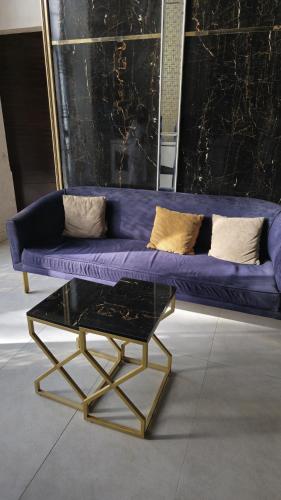a purple couch and a coffee table in a room at Home Sweet Home in Karachi