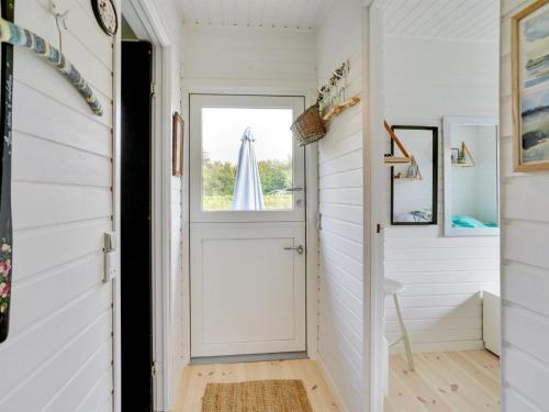 a white hallway with a door and a window at Holiday Home Thersten - 500m to the fjord by Interhome in Løgsted