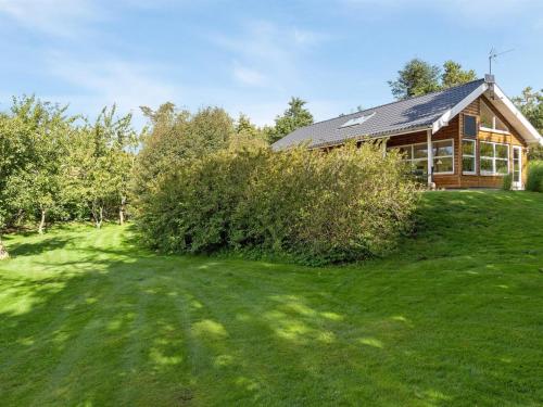 a house on a grassy field with a building at Holiday Home Krister - 250m to the inlet by Interhome in Farsø