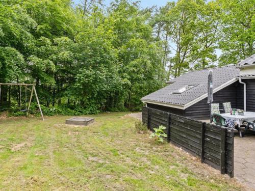 a backyard with a fence and a house at Holiday Home Magh by Interhome in Års