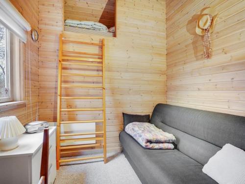 a living room with a couch in a wooden room at Holiday Home Magh by Interhome in Års