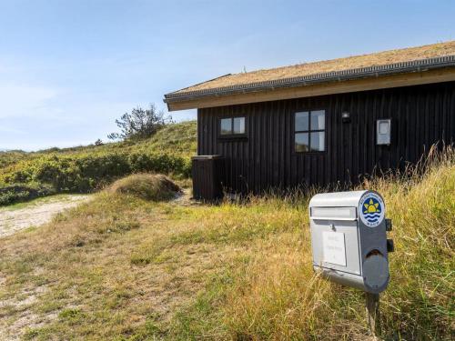 a house with a mailbox in the grass next to a building at Holiday Home Marite - 200m from the sea by Interhome in Pandrup