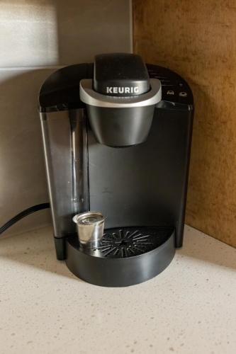 a coffee maker sitting on a counter with a cup at Downtown Bentonville The Cozy Switchback Entire Home with Biking and Trails Steps Away Including Hot Tub and Firepit in Bentonville