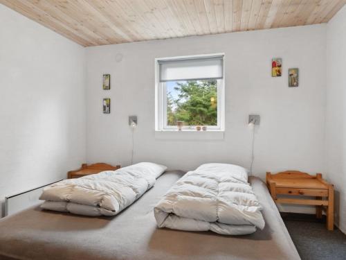 two beds in a white room with a window at Holiday Home Justine - 600m from the sea by Interhome in Fjerritslev