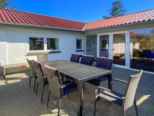 a wooden table and chairs on a patio at Holiday Home Justine - 600m from the sea by Interhome in Fjerritslev