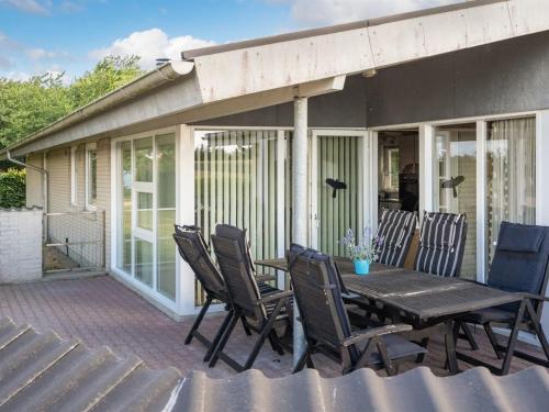 a patio with a wooden table and chairs at Holiday Home Anselma - 800m to the fjord by Interhome in Farsø
