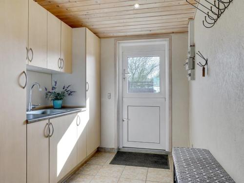 a kitchen with a white door and a sink at Holiday Home Anselma - 800m to the fjord by Interhome in Farsø