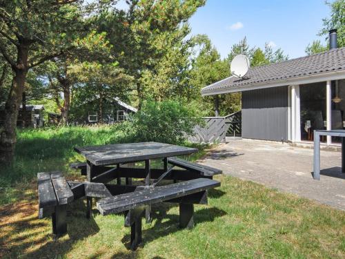 a picnic table and bench outside of a building at Holiday Home Sighbiorn - 950m from the sea by Interhome in Fjerritslev