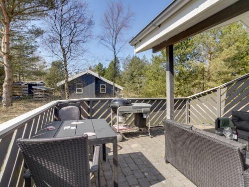a patio with a table and chairs and a grill at Holiday Home Sighbiorn - 950m from the sea by Interhome in Fjerritslev