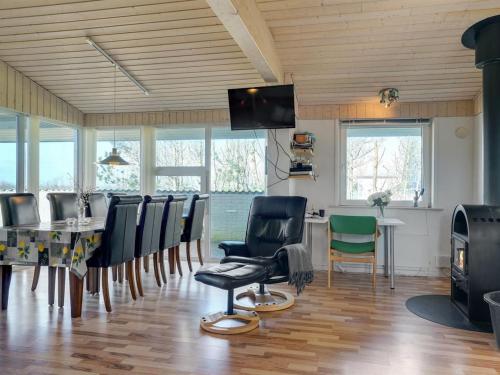a dining room with a table and chairs and a television at Holiday Home Anselma - 800m to the fjord by Interhome in Farsø