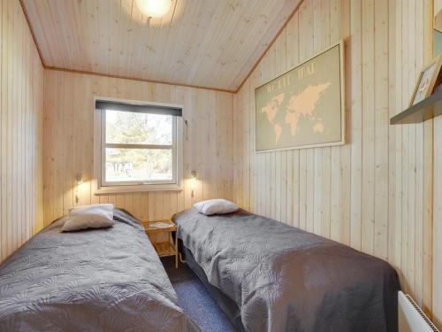 two beds in a room with a window at Holiday Home Sighbiorn - 950m from the sea by Interhome in Fjerritslev