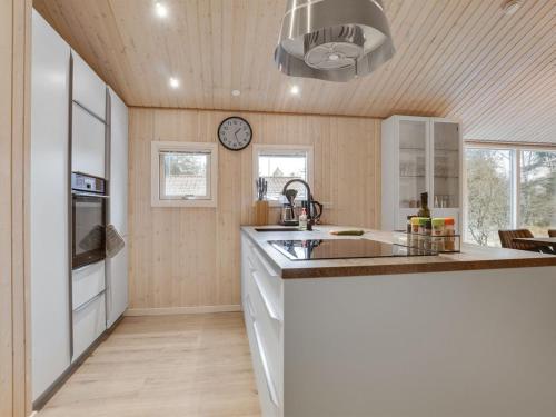 a kitchen with a sink and a clock on the wall at Holiday Home Sighbiorn - 950m from the sea by Interhome in Fjerritslev