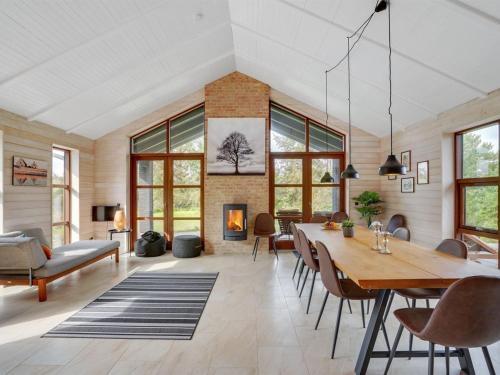 a dining room with a table and a fireplace at Holiday Home Andri - 600m to the fjord by Interhome in Løgstør