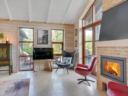a living room with a fireplace and a tv at Holiday Home Andri - 600m to the fjord by Interhome in Løgstør