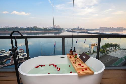 a bath tub on a balcony with a view of the water at R&F Princess Cove by Nest Home at Johor Bahru in Johor Bahru
