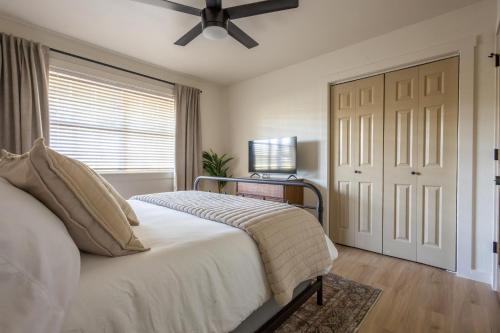 a bedroom with a bed and a ceiling fan at Downtown Bentonville The Cozy Switchback Entire Home with Biking and Trails Steps Away Including Hot Tub and Firepit in Bentonville