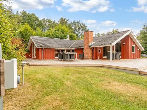 a red house with a patio and a yard at Holiday Home Thurir - 4km from the sea by Interhome in Fjerritslev