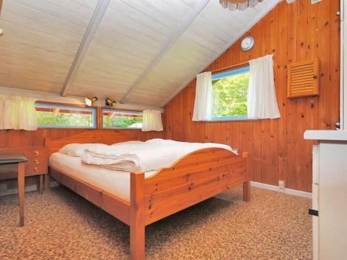 a bedroom with a large bed in a wooden room at Holiday Home Annegrete - 4km from the sea by Interhome in Fjerritslev