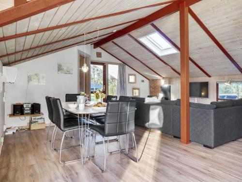a dining room and living room with a table and chairs at Holiday Home Thurir - 4km from the sea by Interhome in Fjerritslev