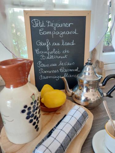 a chalk board with a sign on top of a table at La Campagne de Lili - Chambre et Cuisine sur Terrasse privée in Ongles
