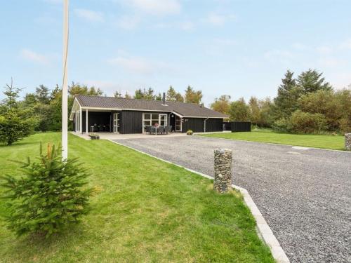 a house with a gravel driveway in front of it at Holiday Home Frida - 700m from the sea by Interhome in Fjerritslev