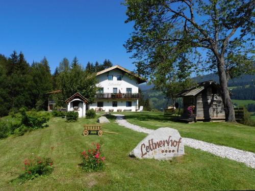 a large white house with a sign in the yard at Bnb Lettnerhof Terrace Family Suite in Monguelfo