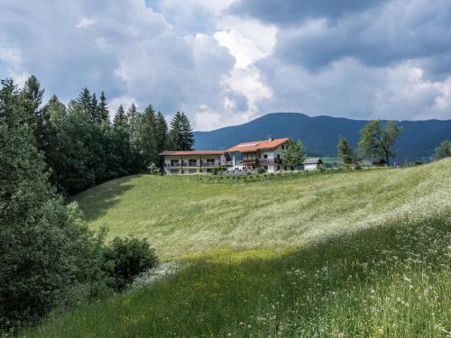 a large house on top of a grassy hill at Bnb Lettnerhof Terrace Family Suite in Monguelfo