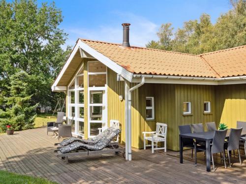 a house with a deck with a table and chairs at Holiday Home Karitte - 5km from the sea by Interhome in Fjerritslev